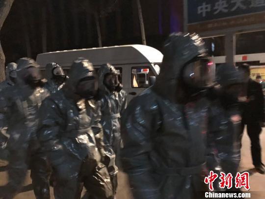 十几名身着防护服的人员头戴面具进入事发地。　胡健 摄